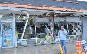 A man makes a call in front of a convenience store's collapsed roof in Fort Pierce, Florida, on Wednesday, October 9.