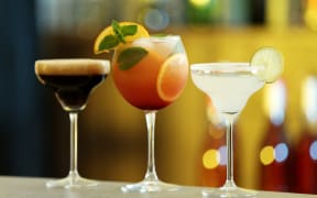 Row of different fresh alcoholic cocktails on bar counter