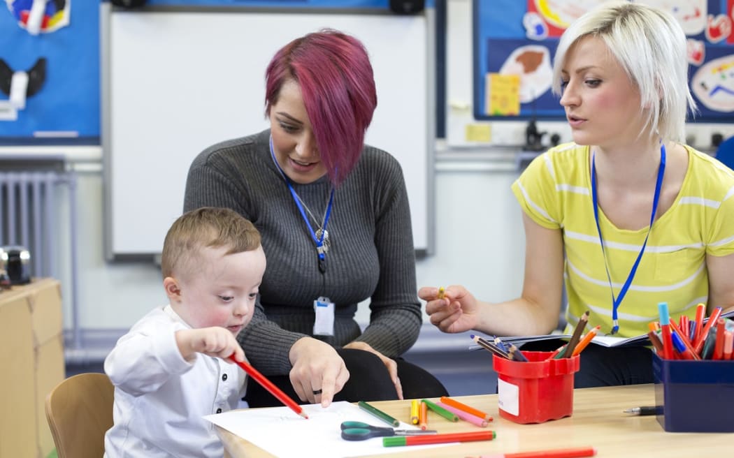 two teacher aides with a young boy