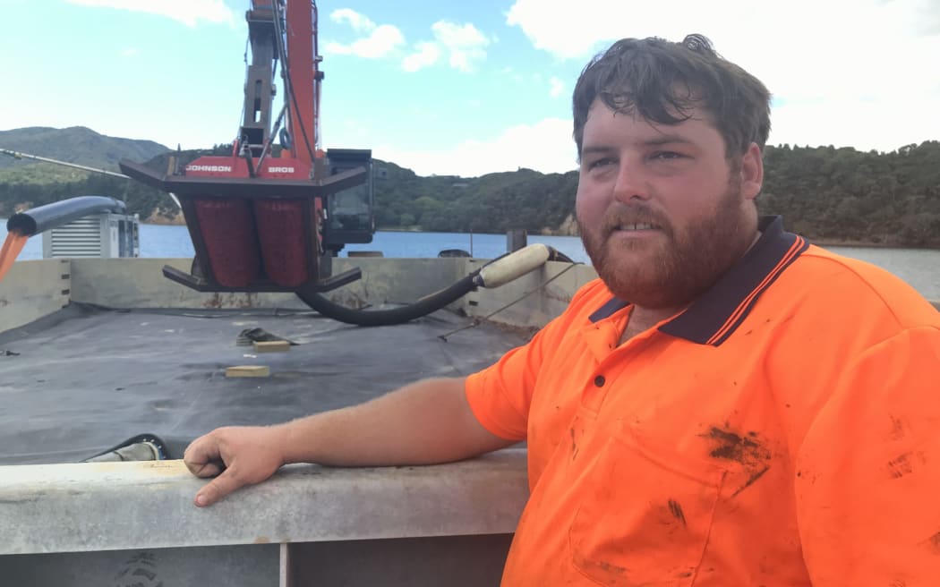 Opua-based Andrew Johnson on the Omākiwi Cove caulerpa dredge barge dueing 2024 caulerpa dredge trials.