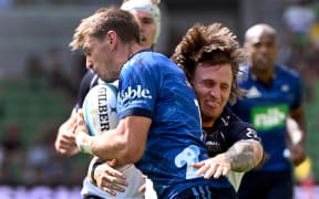 Brumbies player Corey Toole (R) tackles Blues player Beauden Barrett (L) during the Super Rugby match between Auckland Blues and the ACT Brumbies in Melbourne on March 5, 2023.