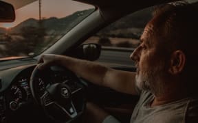 An older man behind steering wheel