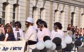 A Lions Club Christmas parade float featuring adults and children in black face