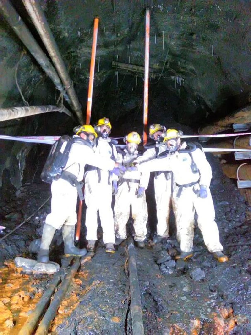 Dinghy Pattinson, Lloyd Steward, Geoff Rubbo, Leon Pigott and Luke Taylor celebrate reaching the roof fall (the black area behind them) after completing their forensics work in the last few metres.