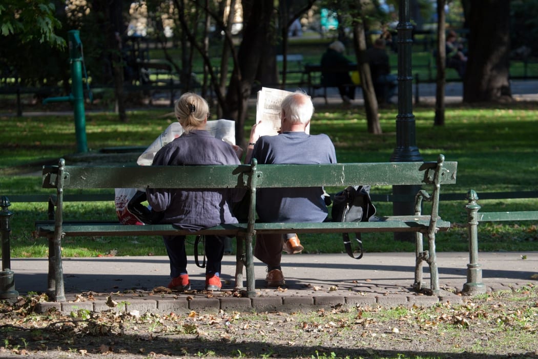 Elderly couple reading newspapers in the park