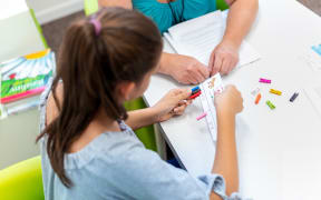 Teacher working with a teenage girl with learning difficulties.