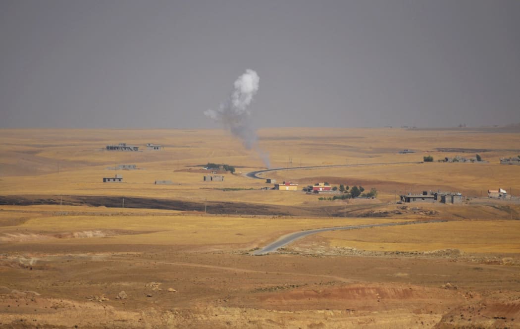Smoke rises during clashes between Peshmerga troops and militants of the Islamic State on the outskirts of Sinjar, west of Mosul.