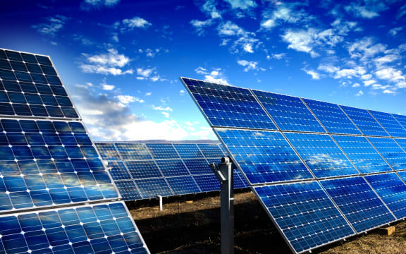 Rows of photovoltaic solar panels and blue sky with clouds