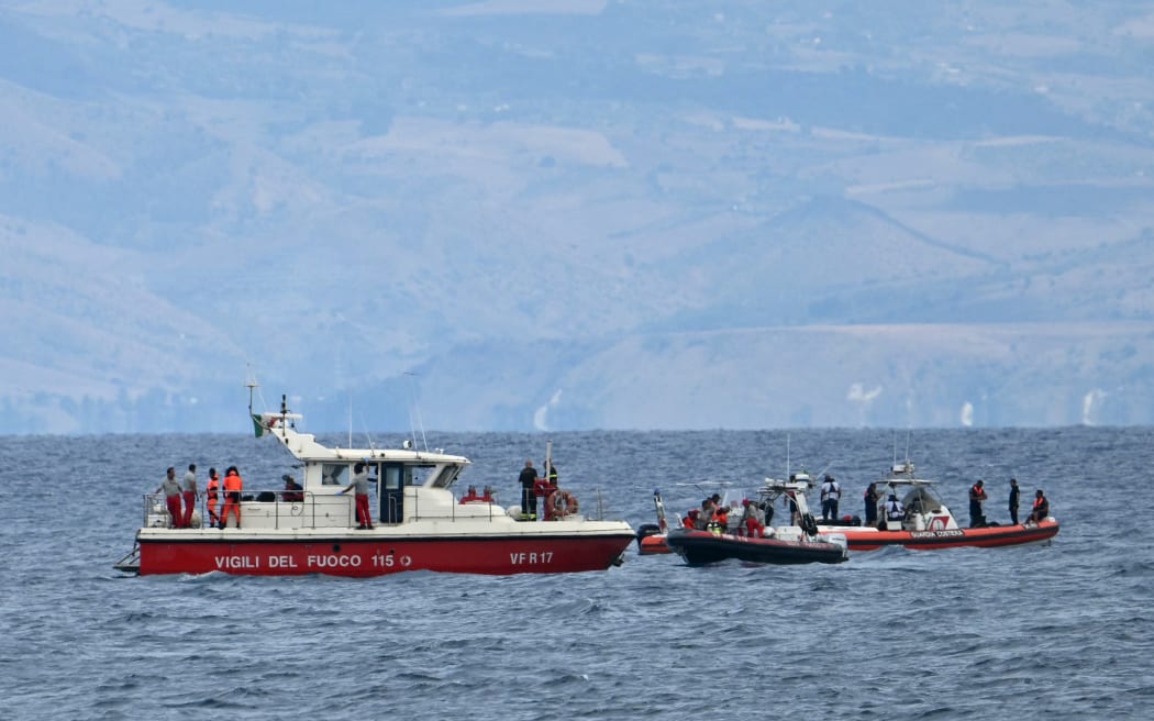 Rescue boats of the Vigili del Fuoco, the Italian Corps. of Firefighters operate off Porticello near Palermo, on August 21, 2024 two days after the British-flagged luxury yacht Bayesian sank. Rescuers with divers and an underwater drone search for six people believed trapped when the boat sank. Among the six missing were UK tech entrepreneur Mike Lynch and his 18-year-old daughter Hannah, and Jonathan Bloomer, the chair of Morgan Stanley International, and his wife Judy. The Bayesian, which had 22 people aboard including 10 crew, was anchored some 700 metres from port before dawn when it was struck by a waterspout, a sort of mini tornado. Fifteen people aboard, including a mother with a one-year-old baby, were plucked to safety; one man has been found dead; and six people remain missing. (Photo by Alberto PIZZOLI / AFP)