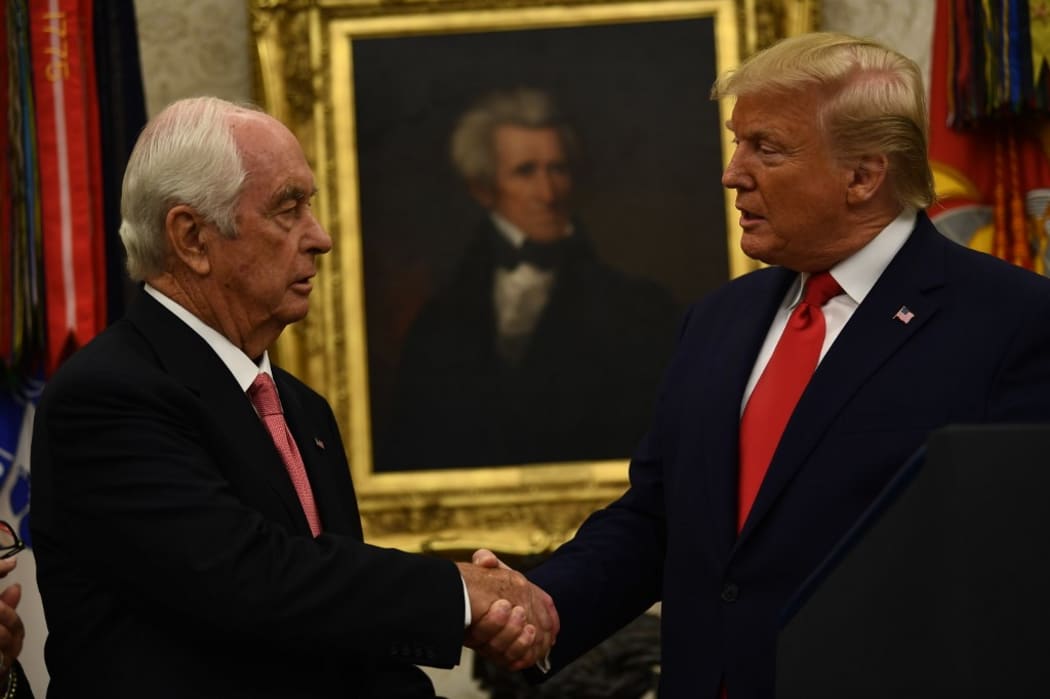 US President Donald J. Trump shakes hands with Roger S. Penske(L) as he welcomes him and his family to the White House before presenting him the Presidential Medal of Freedom on October 24, 2019 in Washington,DC.