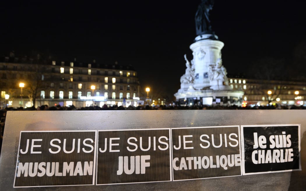 People hold a placard reading "I am Muslim, I am Jewish, I am Catholic, I am Charlie" during a Paris rally.