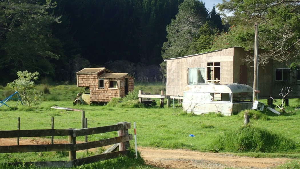An image of two abandoned vehicles in a field inHelena Bay.
