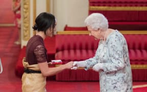 Elizabeth Kite  receives her award from the Queen.
