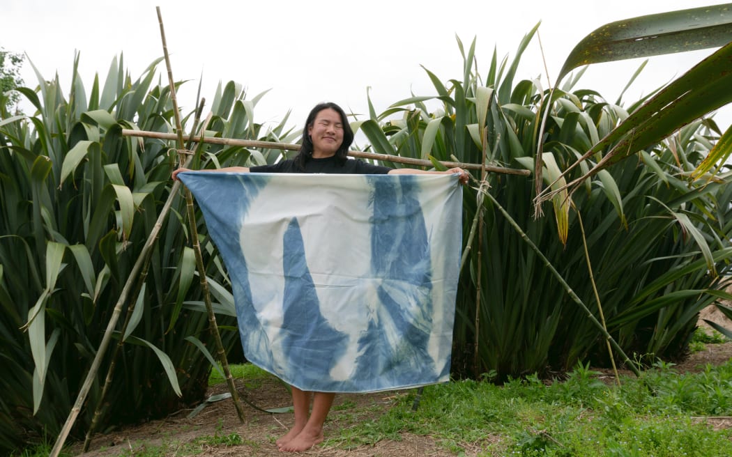 Artist and curator Jieying Cai and their artwork, which is an example of cyanotype, bamboo and muka rope installation.