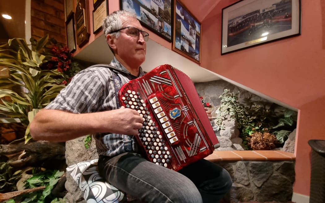 Othmar Hebler, the Taranaki alpine horn group leader, plays a piano accordian.