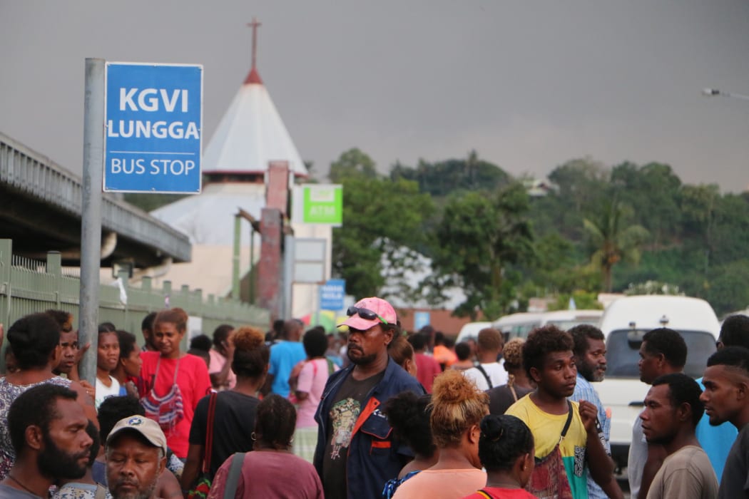 People at a bus stop in Honiara, Solomon Islands
