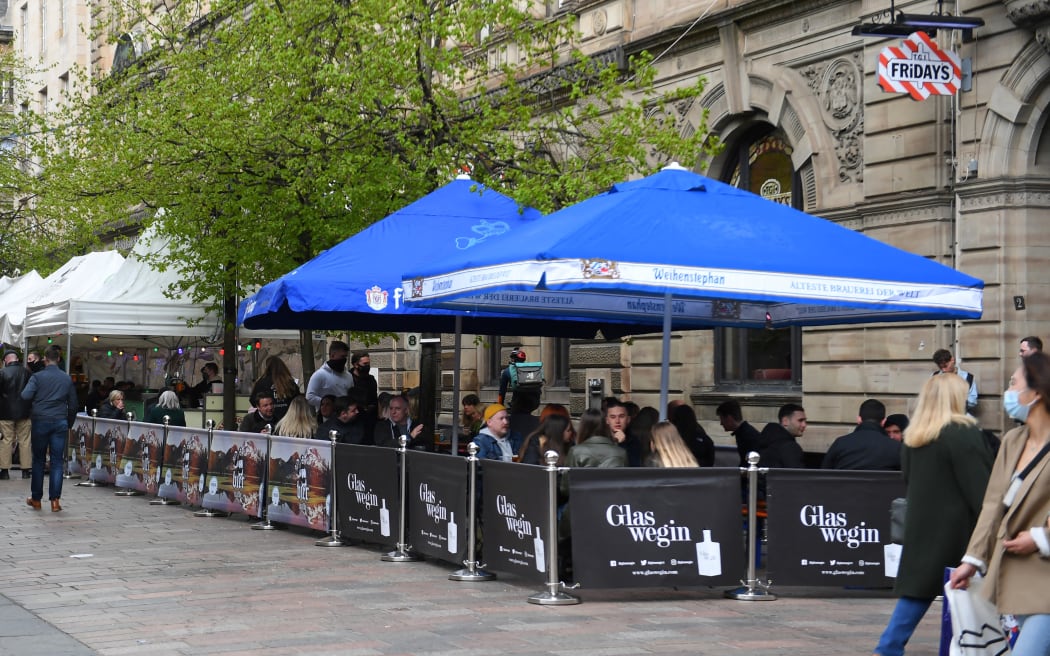 Customers sit at outside tables at a re-opened TGI Fridays restaurant in Glasgow.