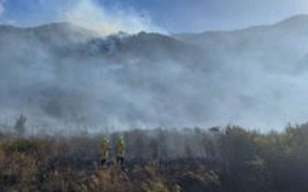 Smoke rises from an inland bush fire bordering the West Coast, with the fire risk continuing to be high.