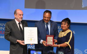 Palau's first lady, Debbie Remengesau, receives the Crans Montana Forum's Prix de la Fondation Award from American Civil Rights Activist, Reverend Jesse Jackson.