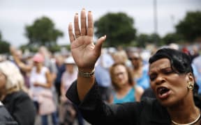 Virginia Beach, Va., council member Sabrina Wooten holds her hand out as she sings during a vigil in response to a fatal shooting at a municipal building in Virginia Beach, Va., Saturday, June 1, 2019.
