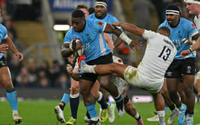 Fiji's centre Josua Tuisova (C) fights off England's centre Ollie Lawrence (R) during the Autumn Nations Series international rugby union match between England and Fiji at Allianz Stadium, Twickenham, in south-west London, on November 8, 2025. (Photo by Glyn KIRK / AFP)