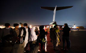 Ppeople forming a line to board the Royal Australian Air Force C-17A Globemaster at Hamid Karzai International Airport in Kabul.