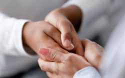 Close up caring African American mother holding child hands, showing love and support, black mum comforting, caressing kid, children protection concept, family enjoying moment together