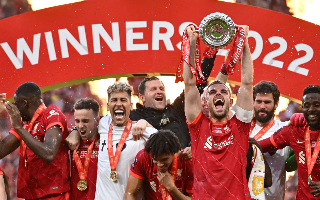 Liverpool's English midfielder Jordan Henderson (front R) holds the trophy as he celebrates with teammates after winning the English FA Cup final football match between Chelsea and Liverpool, at Wembley stadium, in London, on May 14, 2022. (Photo by Ben Stansall / AFP) / NOT FOR MARKETING OR ADVERTISING USE / RESTRICTED TO EDITORIAL USE