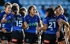 Ruahei Demant (centre) celebrates with her Blues teammates.