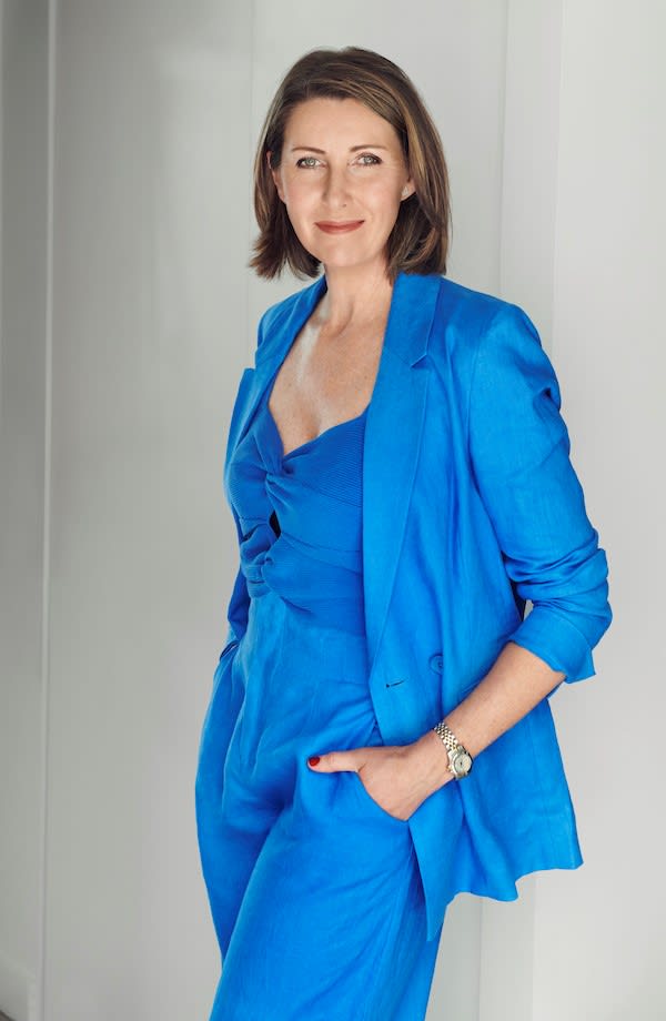 Niki Bezzant smiles at the camera wearing a sky blue blazer, top and trousers.