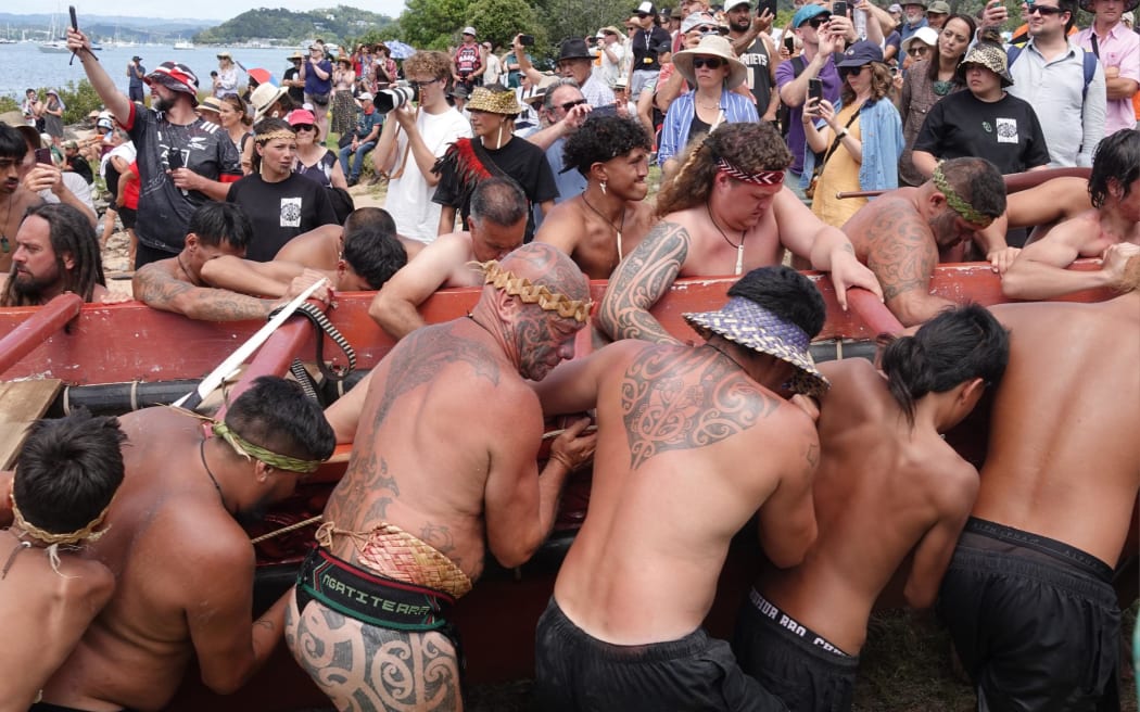 Kaihoe feel the strain as they drag the great waka Ngatokimatawhaorua out of the water.