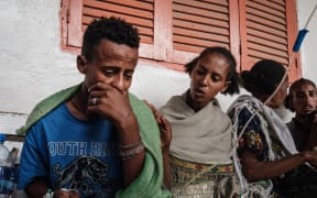 Ataklti Gebremedhin (L), 17, who was injured in his town Togoga in a deadly airstrike on a market, weeps as he recalls his cousin's death