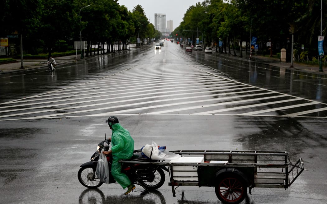 A man rides a motorbike on a road before Typhoon Kajiki makes landfall in Vietnam, in Nghe An province on 25 August, 2025.