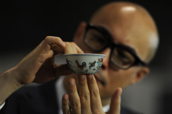 Sotheby's Nicholas Chow holds a "Chicken Cup" which sold for a record price.