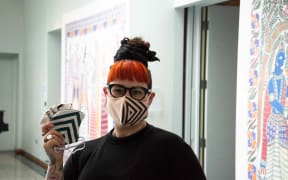 Otago Museum exhibitions and creative services officer Prudence Jopson and her masks crafted from recycled merchandise.