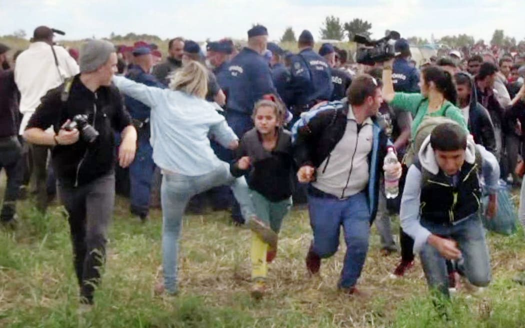 This video grab made on September 9, 2015 shows a Hungarian TV camerawoman kicking a child as she run with other migrants from a police line during disturbances at Roszke, southern Hungary.