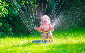 Child playing in a sprinkler