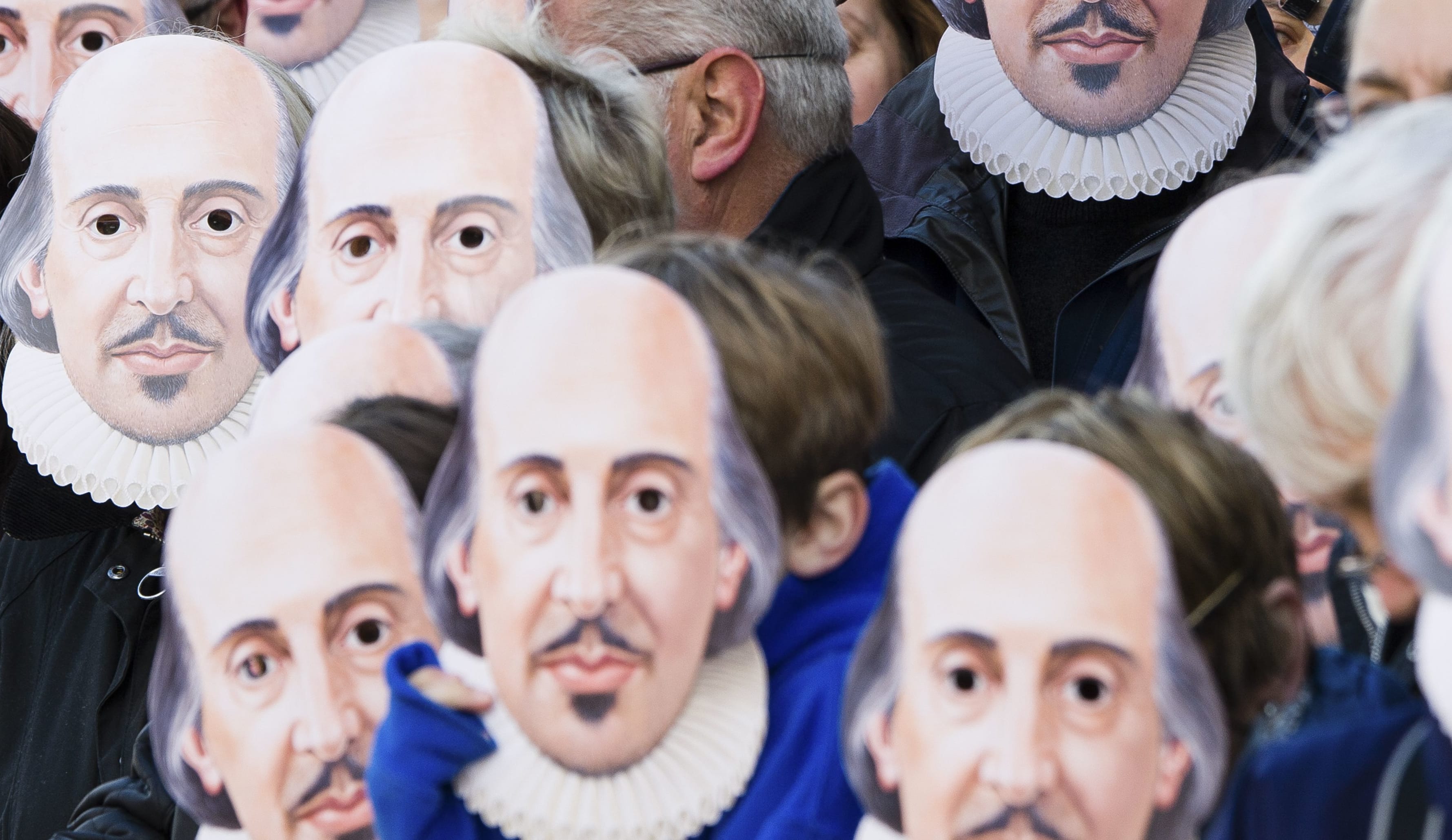 People wearing William Shakespeare masks line the street in Stratford-upon-Avon during a parade to mark 400 years since the bard's death.