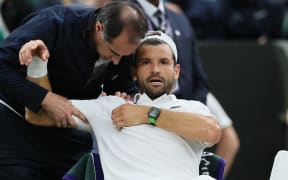 Grigor Dimitrov gets attention for a pectoral muscle injury, forcing his withdrawal from his fourth-round men's singles match against Jannik Sinner at Wimbledon, 7 July, 2025. (Photo by Daisuke Urakami / The Yomiuri Shimbun via AFP)