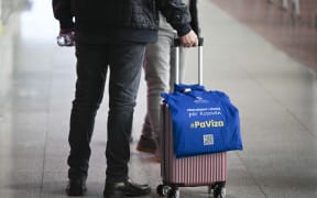 A traveller drags his luggage with a tote bag reading 'Visa Liberalisation for Kosovo #WithoutVisa' at Pristina's International Airport, on 1 January, 2024. A long-awaited European Union's visa liberalisation scheme allowing Kosovo nationals to travel to Europe's borderless zone without a visa came into force on New Year's Day 2024, with the first travellers hailing it as a great relief. The new regime enables Kosovars to travel to the passport-free Schengen zone without a visa for periods of up to 90 days in any 180-day period.