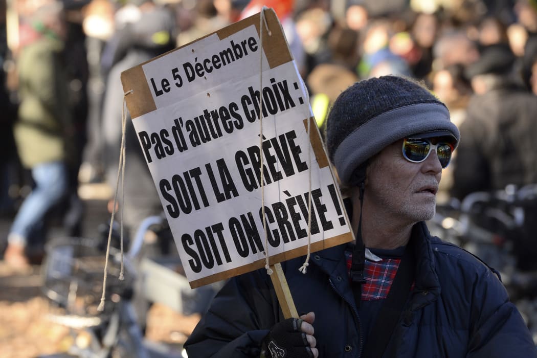 A man holds a placard reading "No choice: the strike or the death" during a demonstration against the pension overhauls, in Bordeaux, on December 5, 2019, as part of a national general strike.