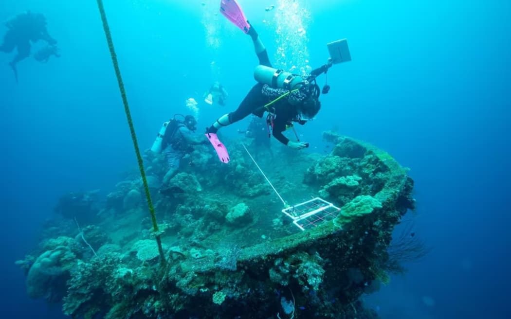 Scuba divers explore the wreckage of a ship that was blown apart during WWII in Chuuk Lagoon. (Supplied: Ranger Walter)