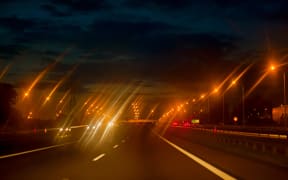 Landscape with cars driving at night.