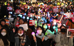 Protesters wave light sticks during a demonstration demanding President Yoon Suk Yeol's resignation outside the National Assembly in Seoul on 10 December, 2024.