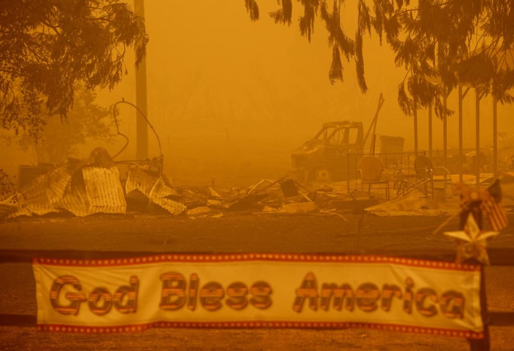 A patriotic banner is seen in front of a burned out property during the Dixie fire in Greenville, California on August 6.