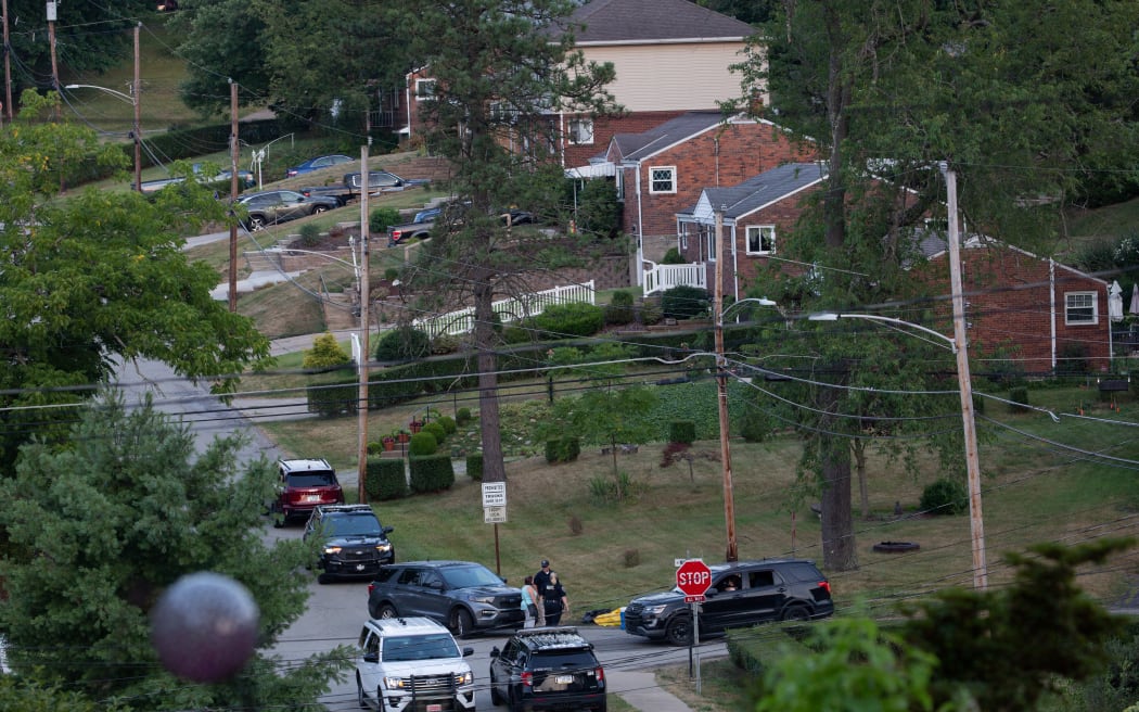 Police continue to block roads around the home of Thomas Matthew Crooks as the FBI continues its investigation into the attempted assassination of former US President Donald Trump in Bethel Park, Pennsylvania, on July 14, 2024. Trump, the presumptive Republican presidential candidate, was shot in the ear July 13 in the opening minutes of his campaign rally in Butler. 
Rivals Joe Biden and Donald Trump urged Americans to show unity on July 14, after an assassination attempt on the Republican that the FBI said was carried out by a shooter with a legally-bought semi-automatic rifle. (Photo by Rebecca DROKE / AFP)