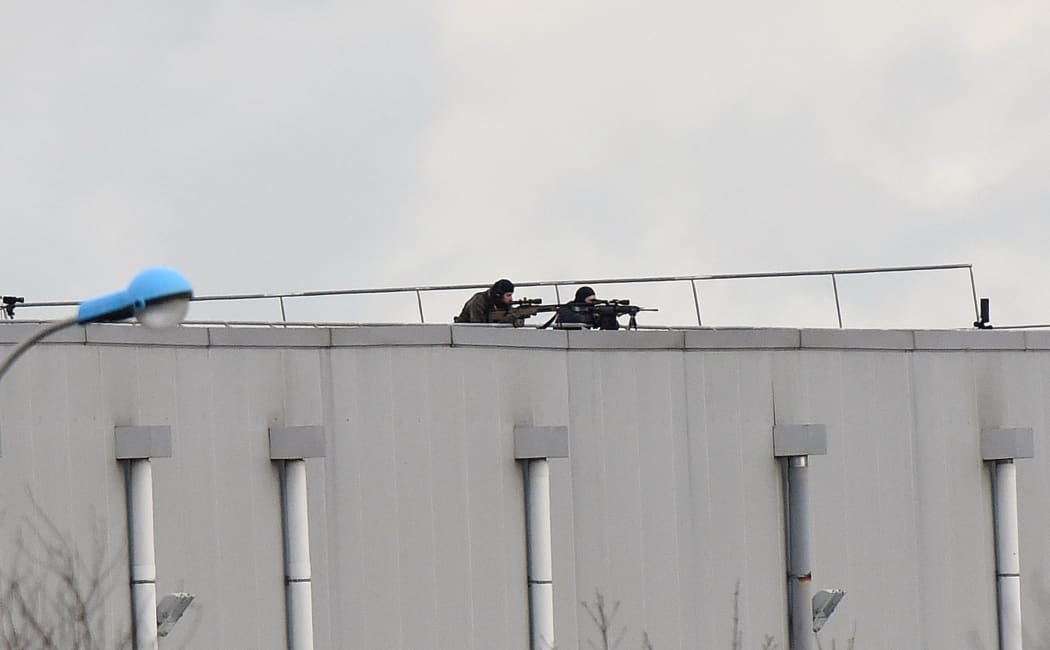 Police marksmen take up a position on a roof in Dammartin-en-Goele, north-east of Paris.