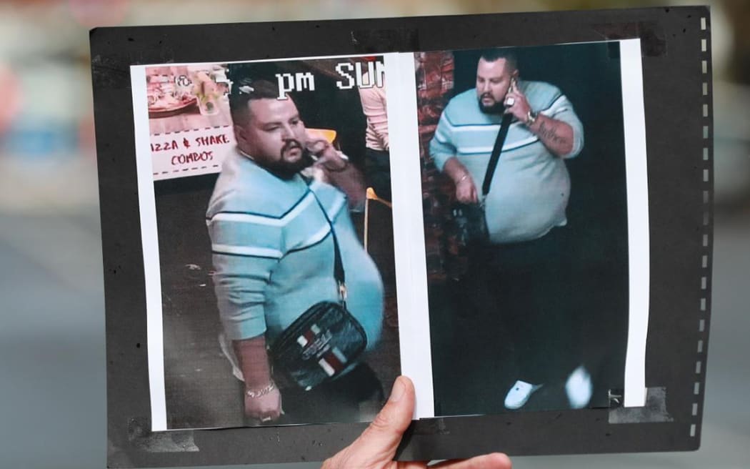 D.I Chris Barry holds up a photograph of an alleged offender during an appeal to media for information regarding a homicide investigation in Ponsonby