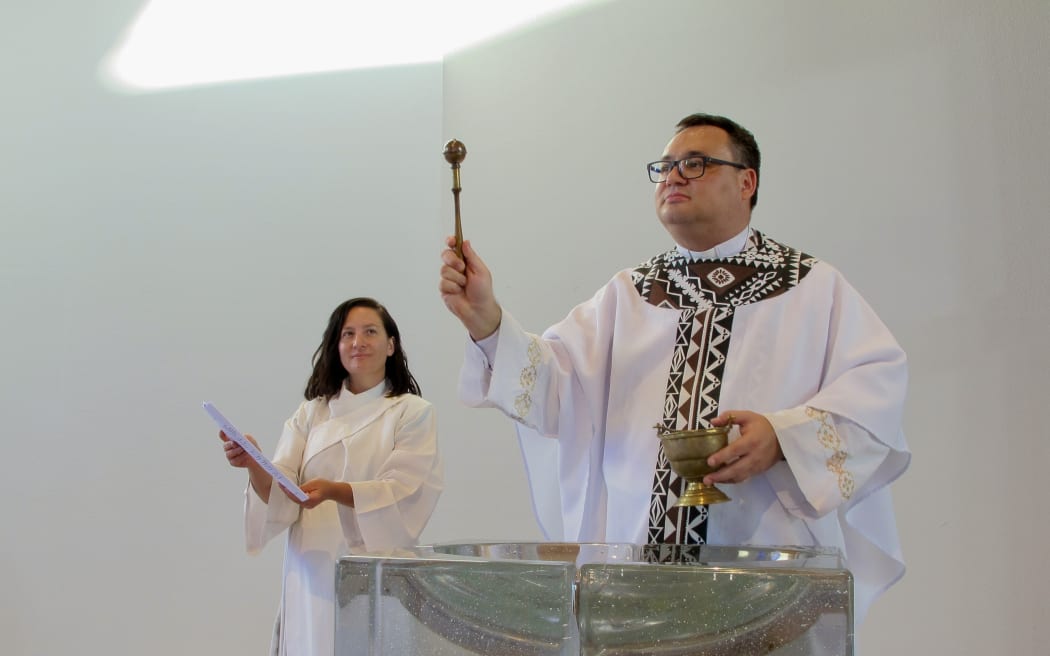 Reverend Ivica Gregurec asperges the congregation from the water in the font while Reverend Hinemoa Carpenter looks on