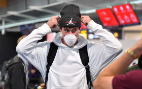 Phoenix's keeper Oliver Sail puts on a mask at Wellington airport as the team heads to Australia for the rest of the season.